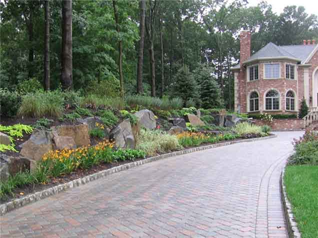 A wide paver walkway, along with some classy hardscaping