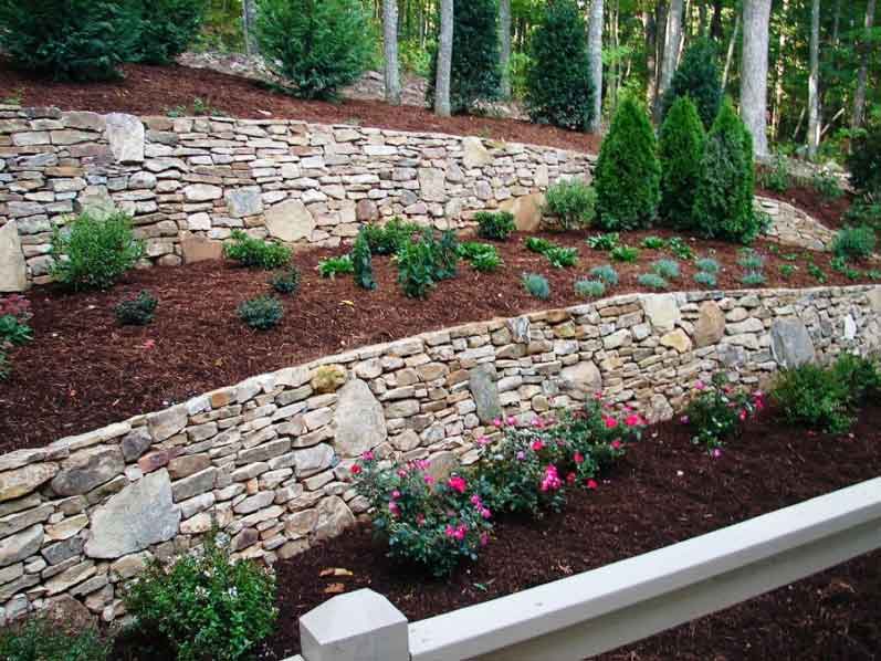 A stone retaining wall with landscaping
